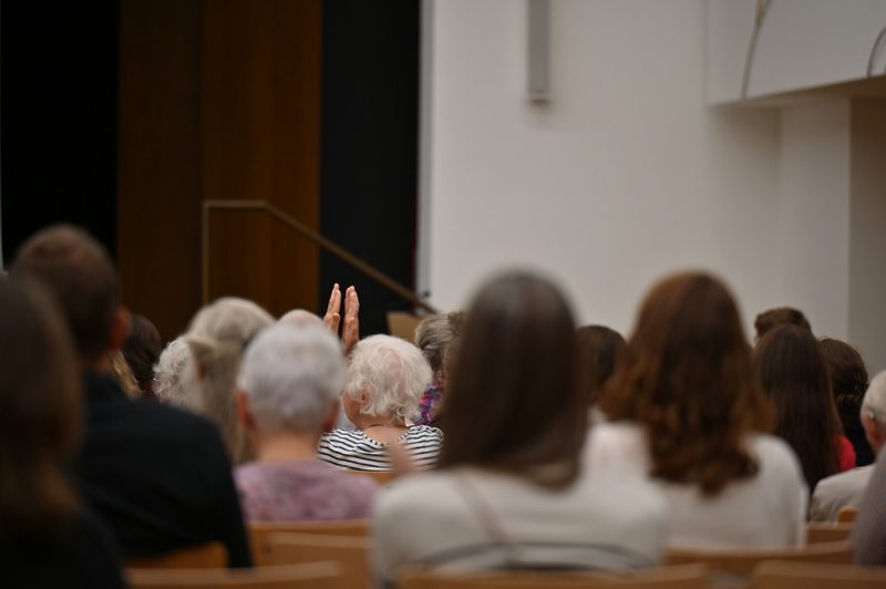 Eine Besucherin applaudiert mit erhobenen Händen im Saal